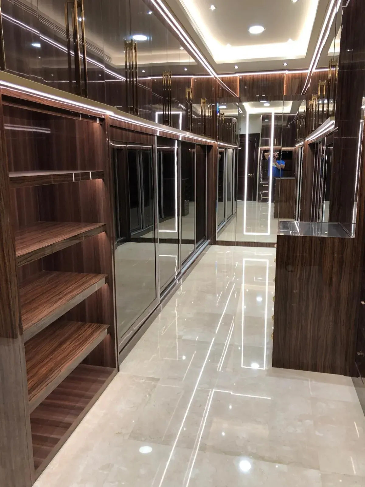 Walnut walk-in dressing room with LED-lit shelving