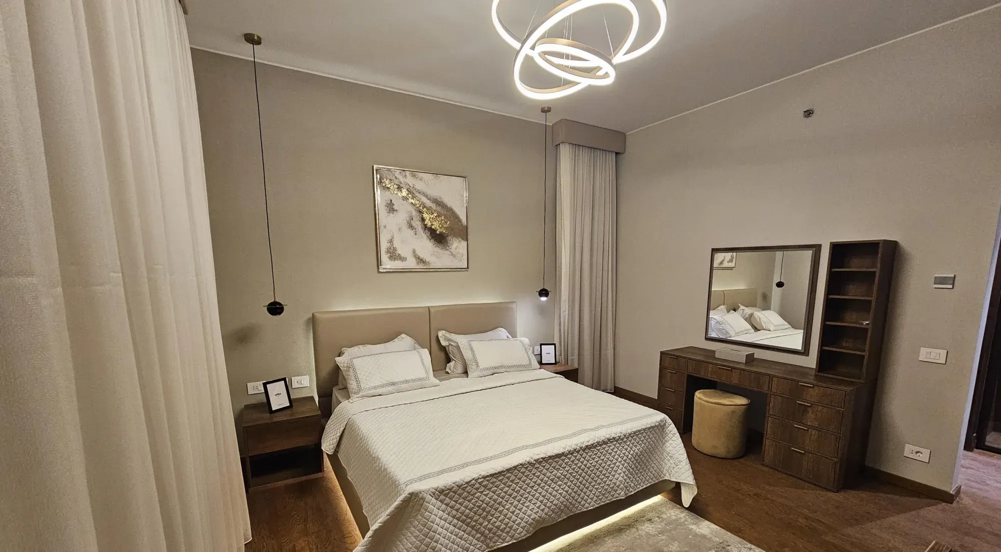 Master bedroom with upholstered headboard and dressing table